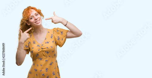 Young redhead woman smiling confident showing and pointing with fingers teeth and mouth. Health concept.