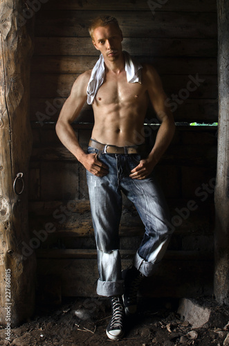 rustic guy in the barn stripped to the waist