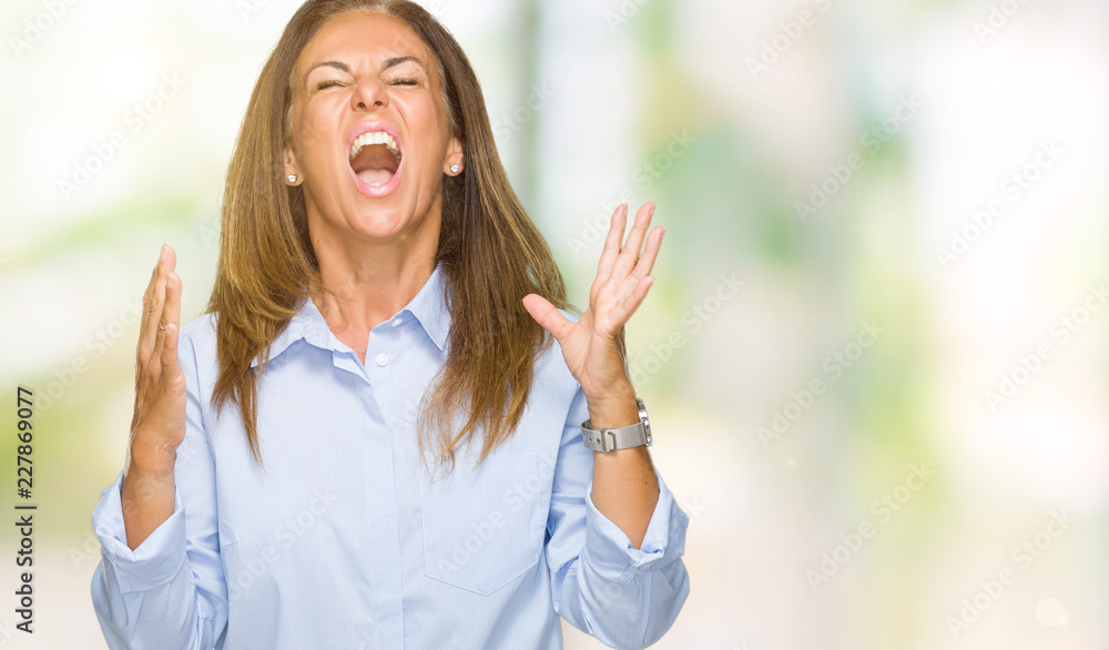 Beautiful middle age business adult woman over isolated background crazy and mad shouting and yelling with aggressive expression and arms raised. Frustration concept. Beautiful middle age business adult woman over isolated background crazy and mad shouting and yelling with aggressive expression and arms raised. Frustration concept.