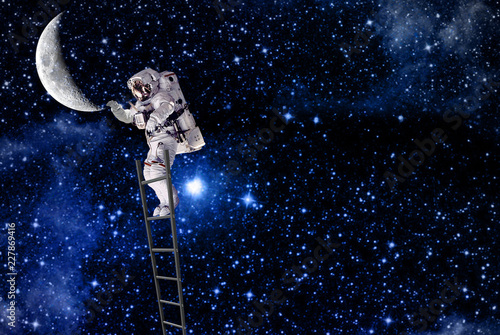 the spaceman on ladder traveling on moon in outer space.elements of this image furnished by NASA