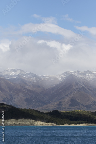 Moody fog and clouds surrounding snow covered mountains