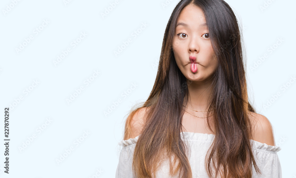 Young asian woman over isolated background making fish face with lips, crazy and comical gesture. Funny expression. Young asian woman over isolated background making fish face with lips, crazy and comical gesture. Funny expression.