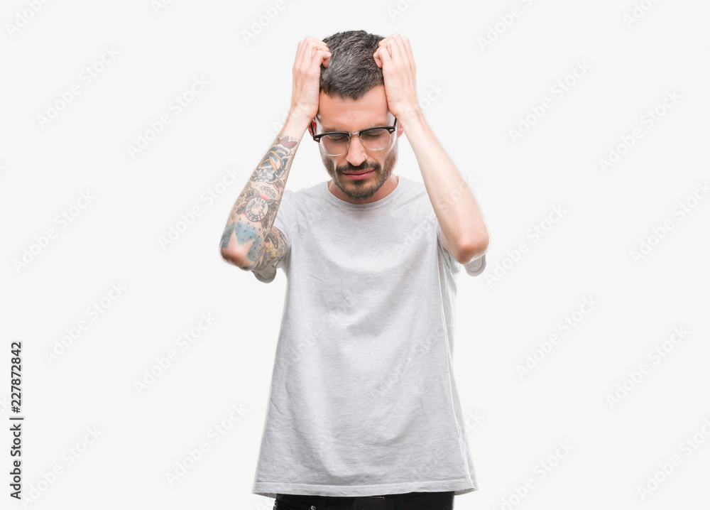 Young tattooed adult man suffering from headache desperate and stressed because pain and migraine. Hands on head. Young tattooed adult man suffering from headache desperate and stressed because pain and migraine. Hands on head.