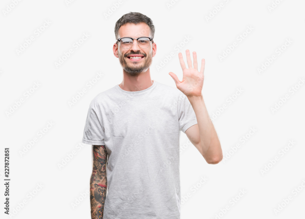 Young tattooed adult man showing and pointing up with fingers number five while smiling confident and happy. Young tattooed adult man showing and pointing up with fingers number five while smiling confident and happy.