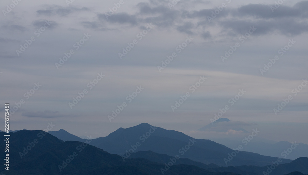 Mountains, with Mt. Fuji hiding behind clouds just behind Mountains, with Mt. Fuji hiding behind clouds just behind