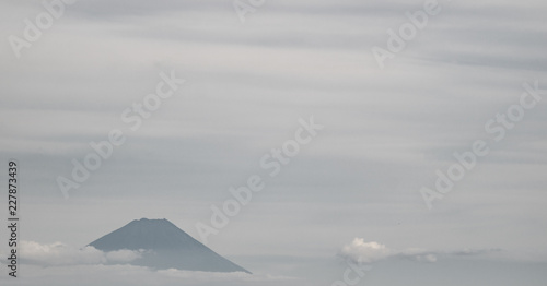 The tip of Mt. Fuji in a cloudy sky