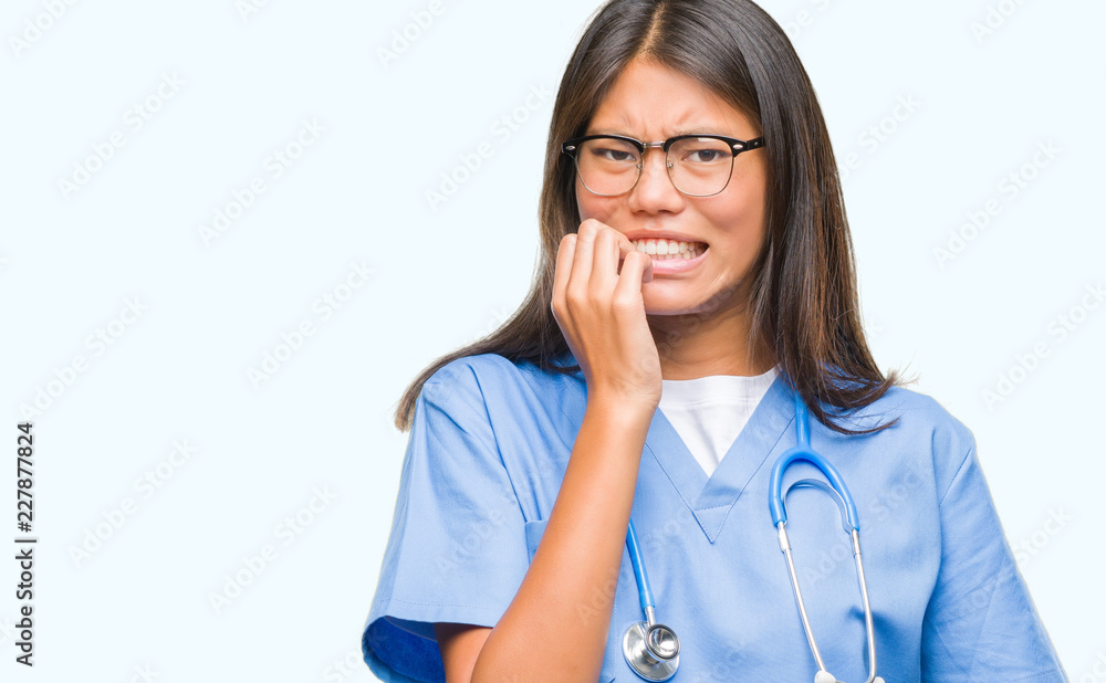 Young asian doctor woman over isolated background looking stressed and nervous with hands on mouth biting nails. Anxiety problem. Young asian doctor woman over isolated background looking stressed and nervous with hands on mouth biting nails. Anxiety problem.