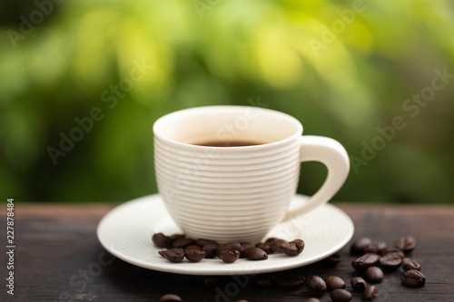 white cup of black coffee with green background
