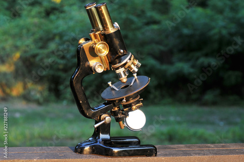 Antique binocular microscope on a black background