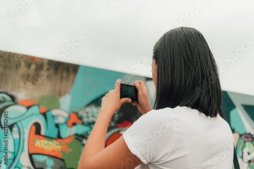 Woman enjoy taking photo of an unknown abandoned building.