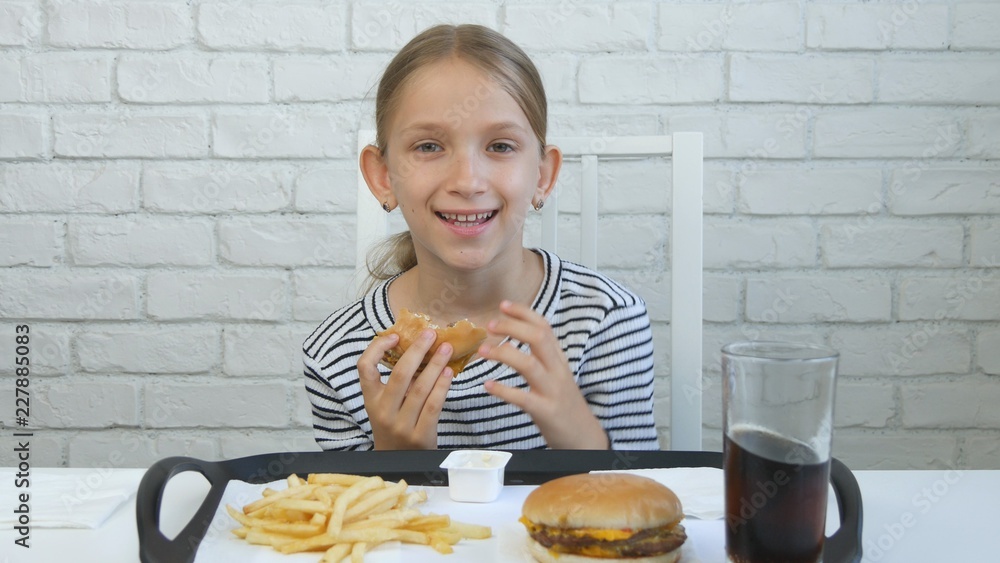 Child Eating Hamburger in Restaurant, Kid and Fast Food, Girl Drinking Juice Child Eating Hamburger in Restaurant, Kid and Fast Food, Girl Drinking Juice