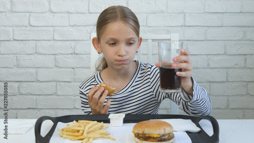 Child Eating Hamburger in Restaurant, Kid and Fast Food, Girl Drinking Juice Child Eating Hamburger in Restaurant, Kid and Fast Food, Girl Drinking Juice