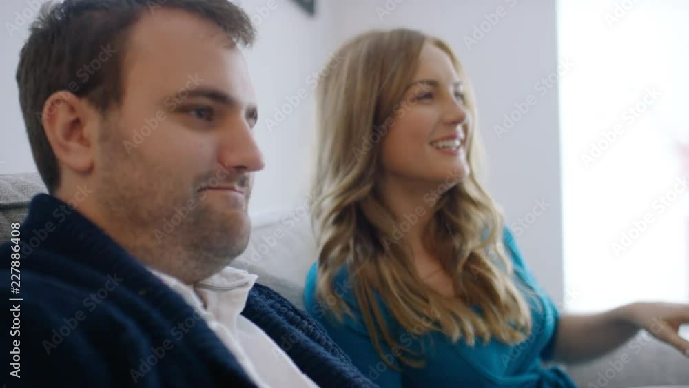 Young couple at home relaxing as the man plays video games Young couple at home relaxing as the man plays video games