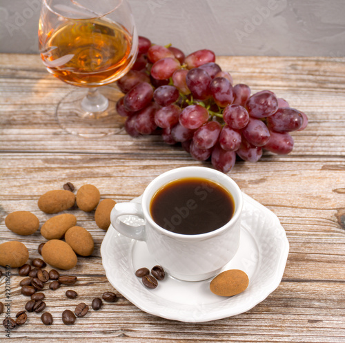 Fototapeta Naklejka Na Ścianę i Meble -  Black coffie and glass with brandy served with grape and chocolate