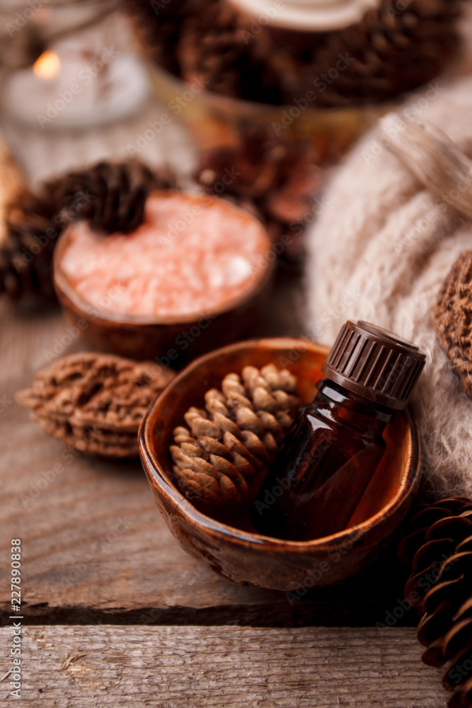 Close up of beautiful spa composition in wellness center, Spa ftreatmeent, aromatherapy oil and Pine cones, monochrome concept Close up of beautiful spa composition in wellness center, Spa ftreatmeent, aromatherapy oil and Pine cones, monochrome concept