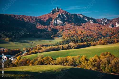 Autumn landscape, colorful forest, meadow and rocky hills