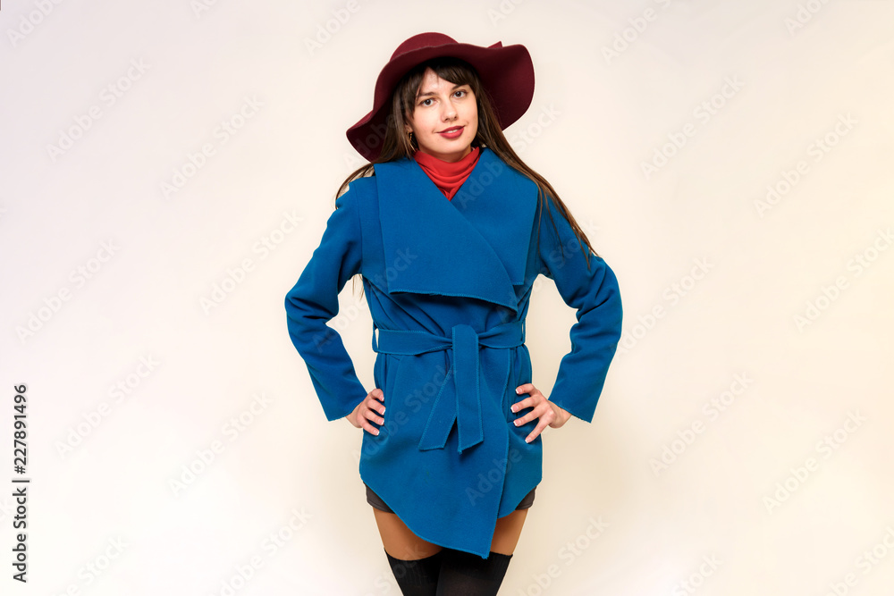 Studio photo portrait of a beautiful brunette girl on a white background in a coat and hat Studio photo portrait of a beautiful brunette girl on a white background in a coat and hat