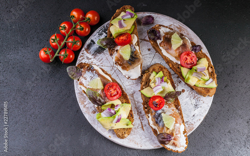 Sandwiches with smoked mackerel, avocado and red onion.