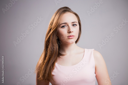 Horizontal portrait of a unhappy woman on gray background