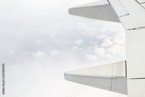 Beautiful close up view of airplane wing in the cloudy sky during the flight.