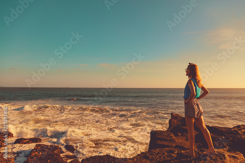 Girl enjoying the tropical sunset on the ocean shore.