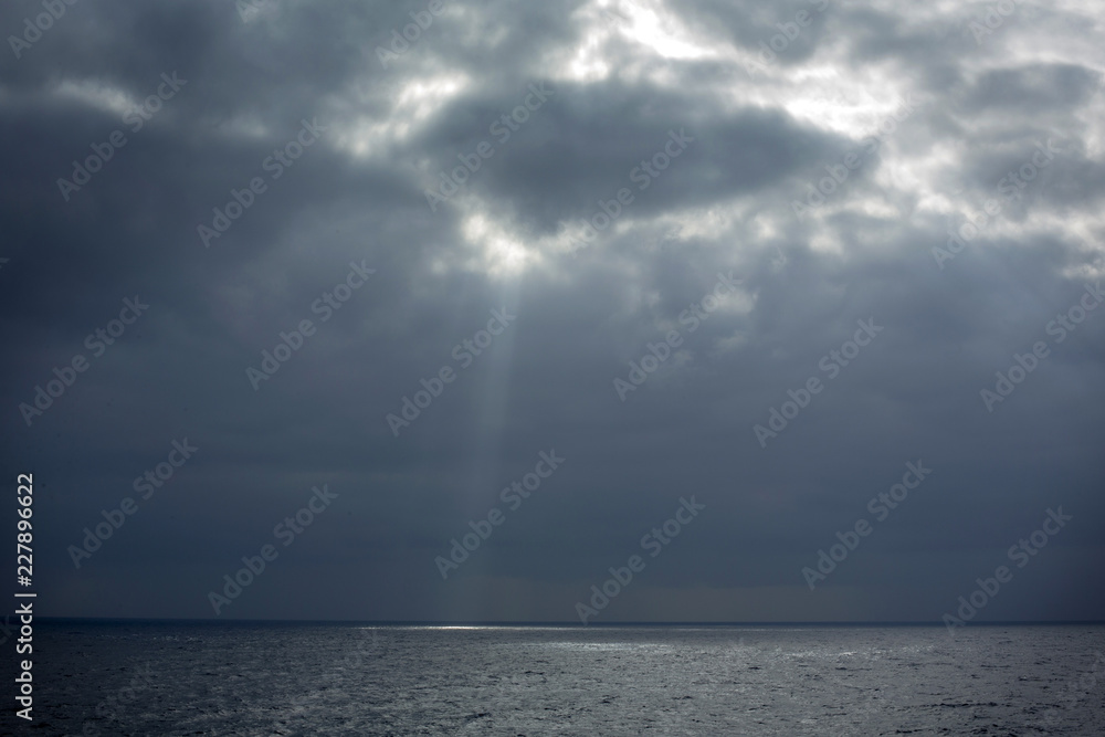 rays of light through the clouds falling on the sea