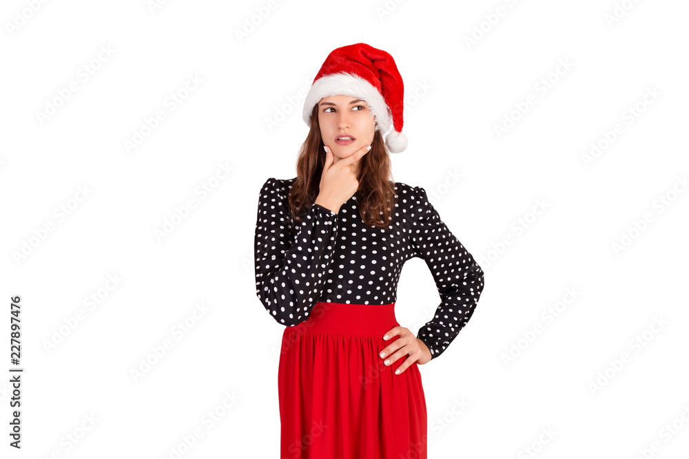 Dreamy attractive, thinking and confident young woman in dress, holding palm on cheek and gazing at upper left corner. emotional girl in santa claus christmas hat isolated on white background Dreamy attractive, thinking and confident young woman in dress, holding palm on cheek and gazing at upper left corner. emotional girl in santa claus christmas hat isolated on white background