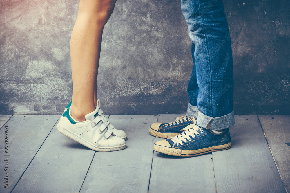 Concept of love relationship, with closeup on legs and shoes of a couple  showing their love