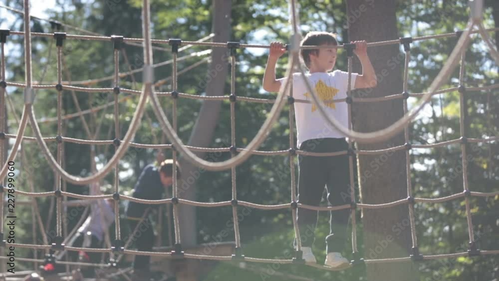 Adventure climbing high wire park , child climbing rope structure summertime outdoors Adventure climbing high wire park , child climbing rope structure summertime outdoors