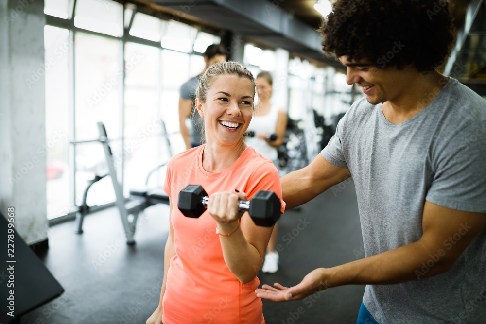 Young beautiful woman doing exercises with personal trainer Young beautiful woman doing exercises with personal trainer
