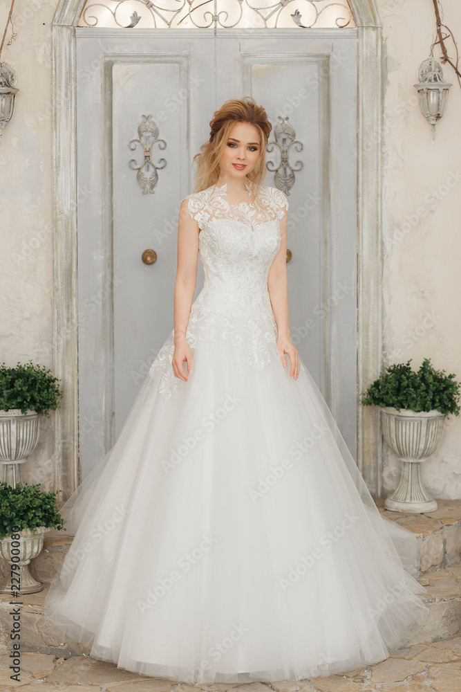 beautiful bride in a white fluffy dress, wedding theme, freedom. Full-lenght portrait on rustic wall and window background beautiful bride in a white fluffy dress, wedding theme, freedom. Full-lenght portrait on rustic wall and window background