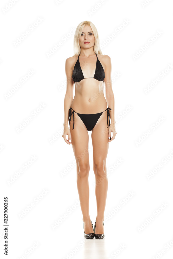 young pretty blonde woman posing in black bikini on white background young pretty blonde woman posing in black bikini on white background
