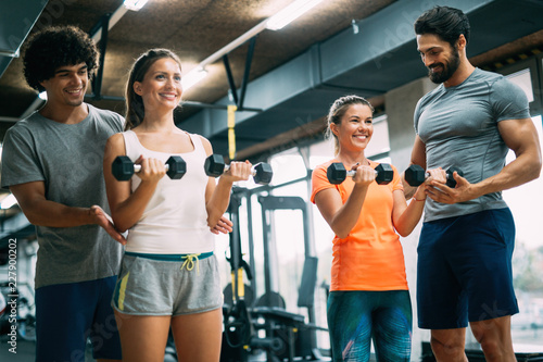 Two attractive women exercising with personal trainers