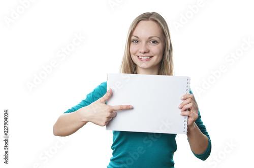 happy young blonde woman holding blank sign and pointing to copy space
