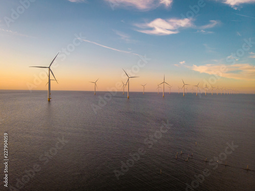 windmill farm drone view from above during sunset, windmill park offshore ocean photo