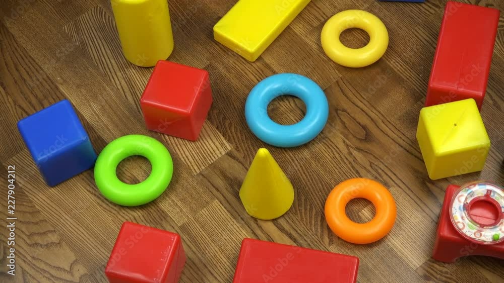 Multicolored developing children's plastic cubes on a wooden floor. Multicolored developing children's plastic cubes on a wooden floor.
