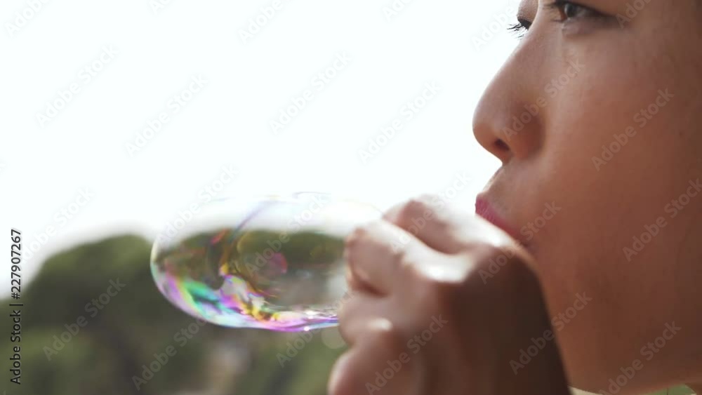 making soap bubbles. Chinese woman playing with soap bubbles- slow motion making soap bubbles. Chinese woman playing with soap bubbles- slow motion
