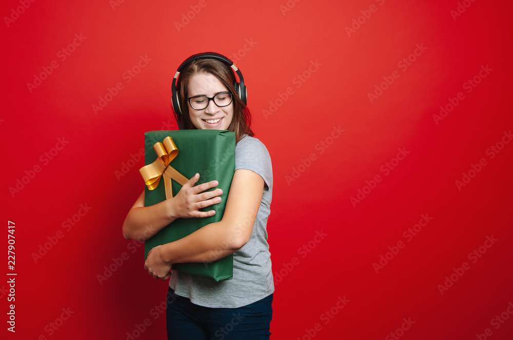 Happy girl holding big gift over red background Happy girl holding big gift over red background
