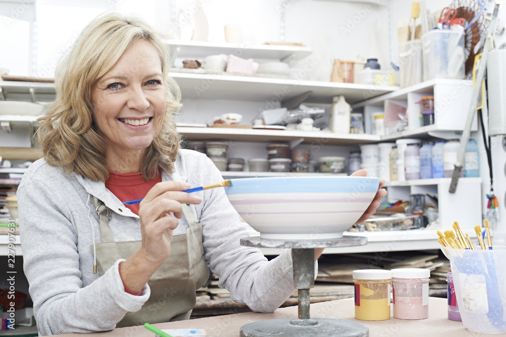 Portrait Of Mature Woman Decorating Bowl In Pottery Class Portrait Of Mature Woman Decorating Bowl In Pottery Class