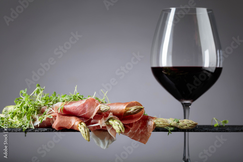 Asparagus wrapped in prosciutto with red wine .