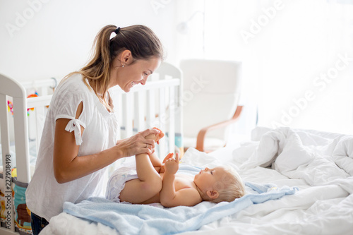 Papier peint Young mom, changing baby diaper after bath