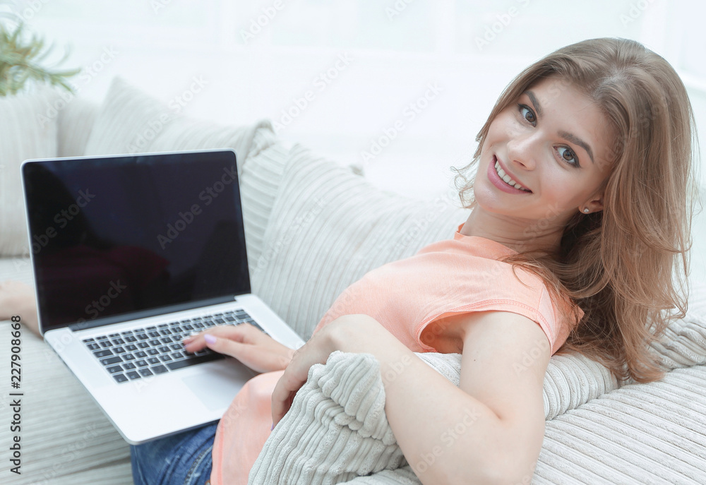 portret young woman working with laptop sitting on sofa portret young woman working with laptop sitting on sofa