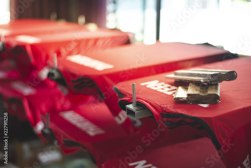 Red t-shirt screen printing, worker working on manual screen printing on t-shirt.