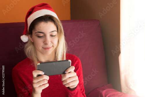 Happy teenage girl with the phone at Christmas photo