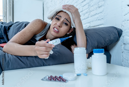 Foto Beautiful woman suffering from cold feeling awful lying in bed