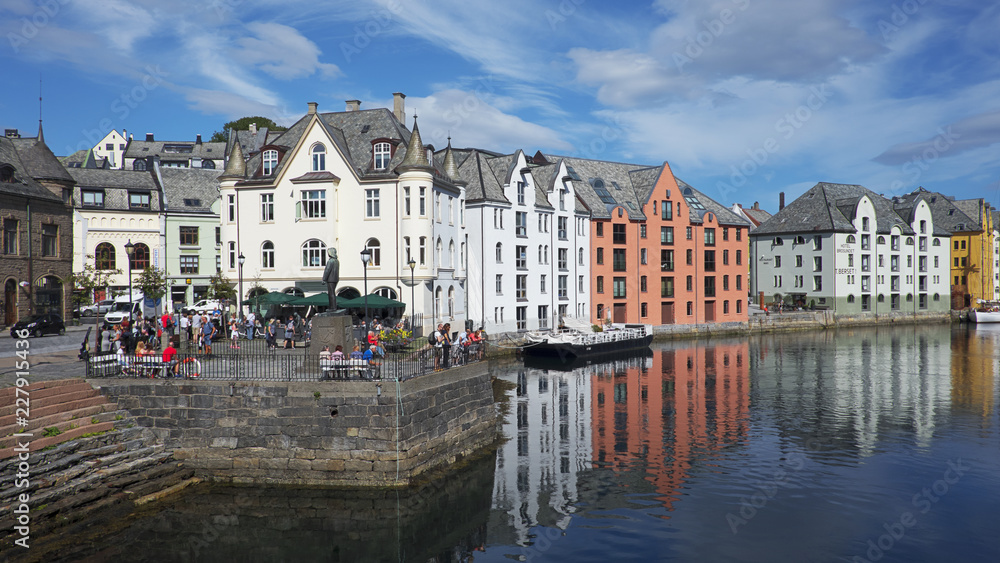 View of the famous clear blue canal lined up with Art Nouveau architectural style buildings, a Scandinavian picturesque town, redesigned after a terrific fire in 1904, in Alesund, Norway