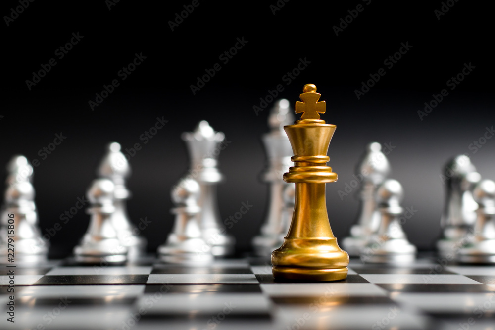 Gold king chess piece face with another silver team on black background (Concept for company strategy, business victory or decision) Gold king chess piece face with another silver team on black background (Concept for company strategy, business victory or decision)