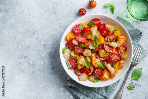 panzanella, traditional italian tomato and bread salad in white bowl