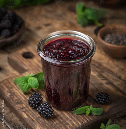blackberry and chia seeds jam in glass. wooden background