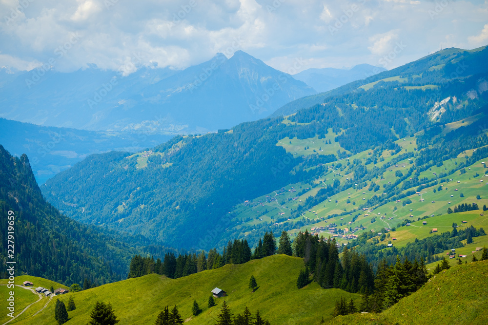 Summer landscape of green hills an mountain village in Switzerland